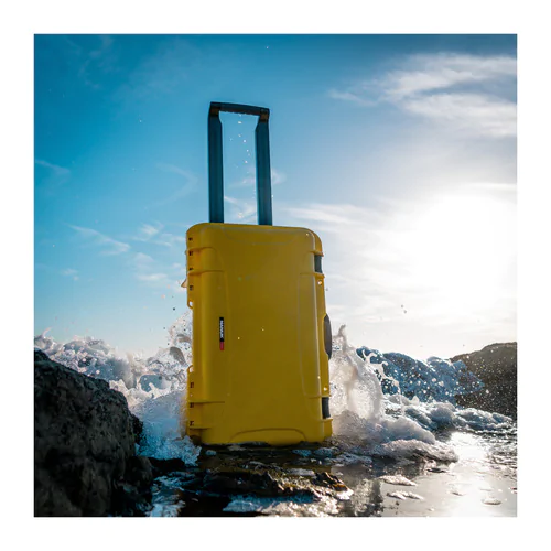 Nanuk 935 case in yellow with sea lapping around its base.